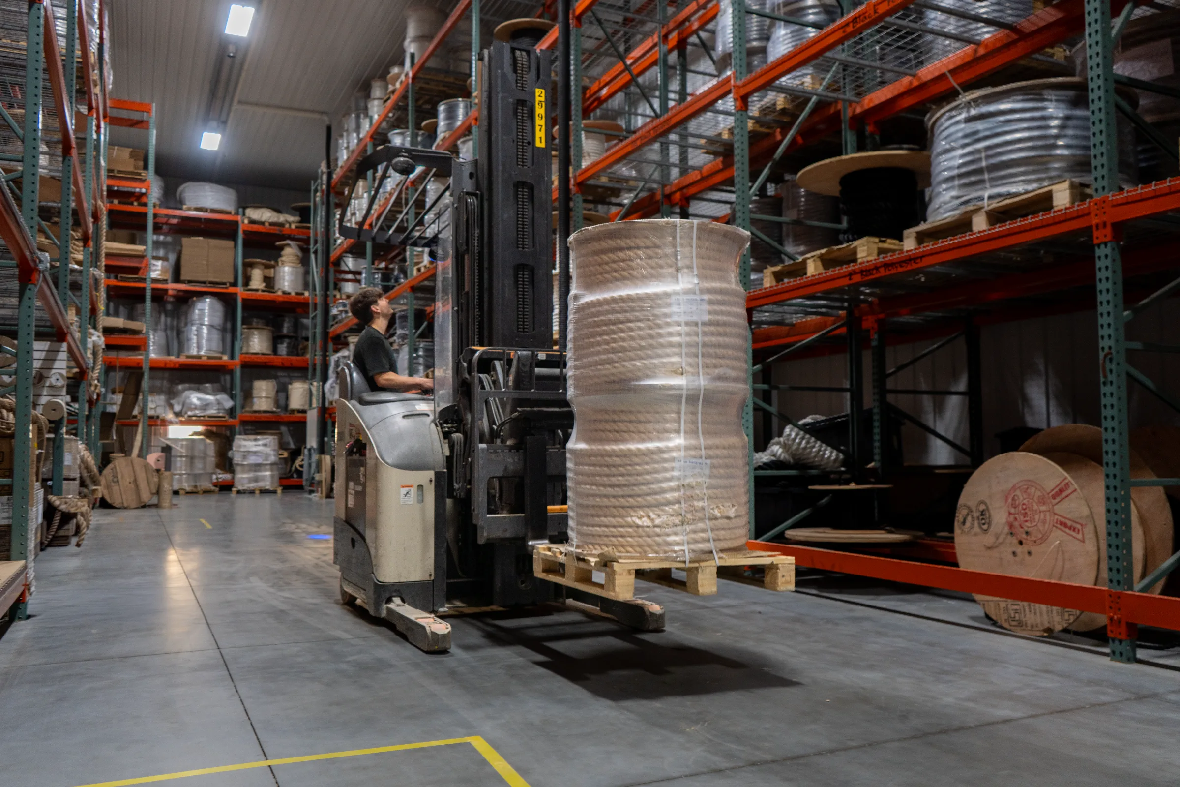 Employee on a forklift looking for a pallet racking spot